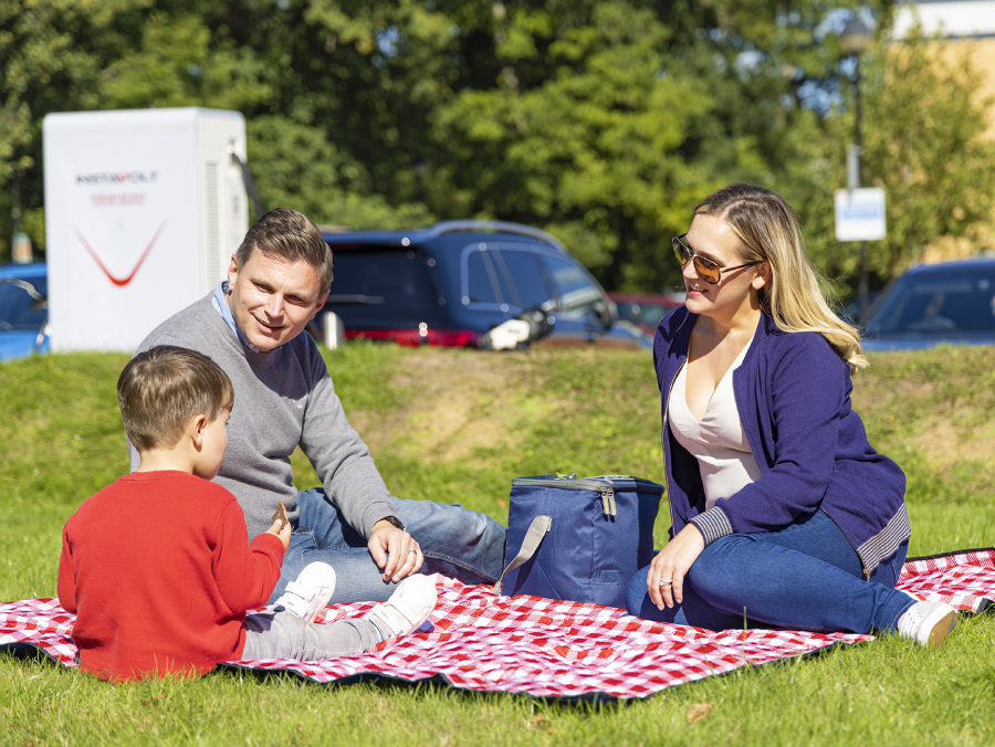 Family having a picnic waiting for car to charge